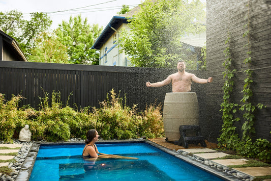 Man flexing while taking an ice bath in his ice barrel