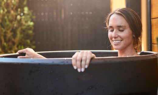 Woman relaxing while taking an ice bath in an ice barrel