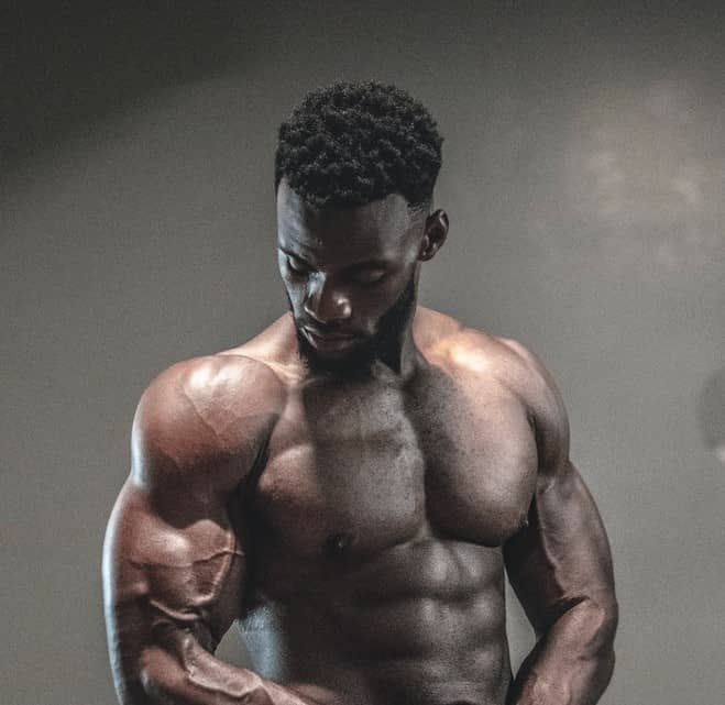 muscular man standing under a light