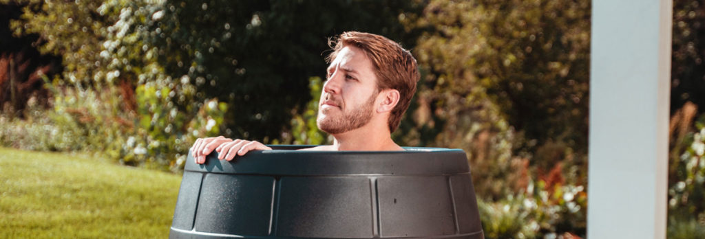 Man taking a full-body, upright ice bath using Ice Barrel